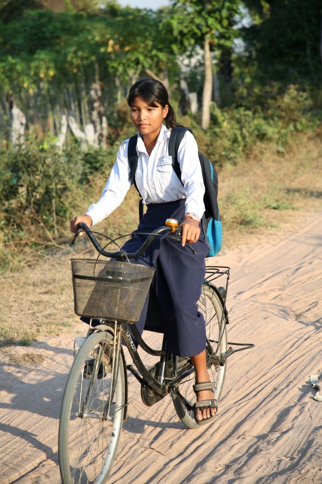 A young girl fitted with prosthesis is riding her bicycle 