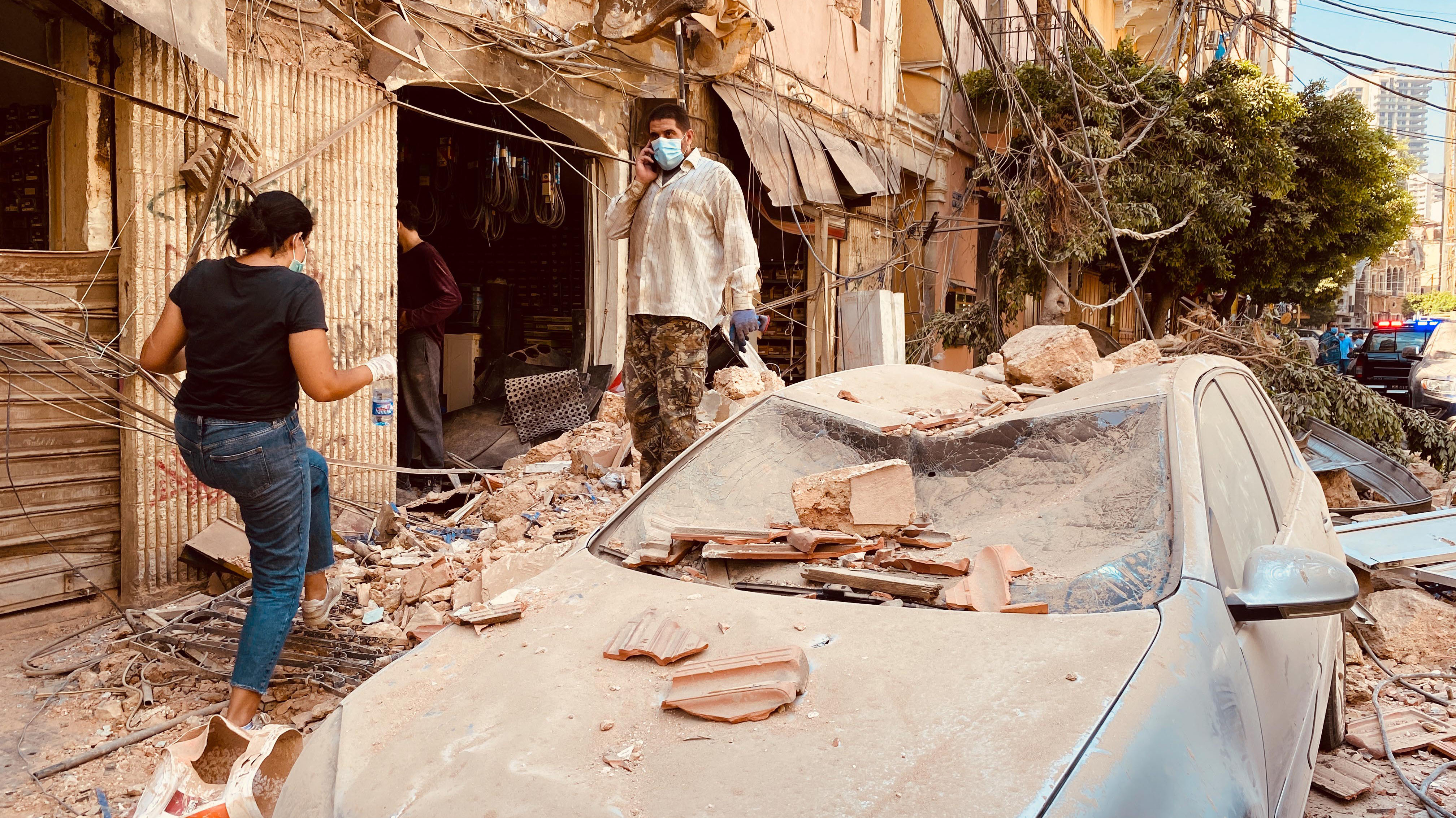 Beyrouth, Liban, 5 août: les passants portent des masques et circulent entre les voitures endommagées après une violente explosion. Elle a touché la capitale libanaise ce mardi 4 août tuant 80 personnes et blessant près de 4 000