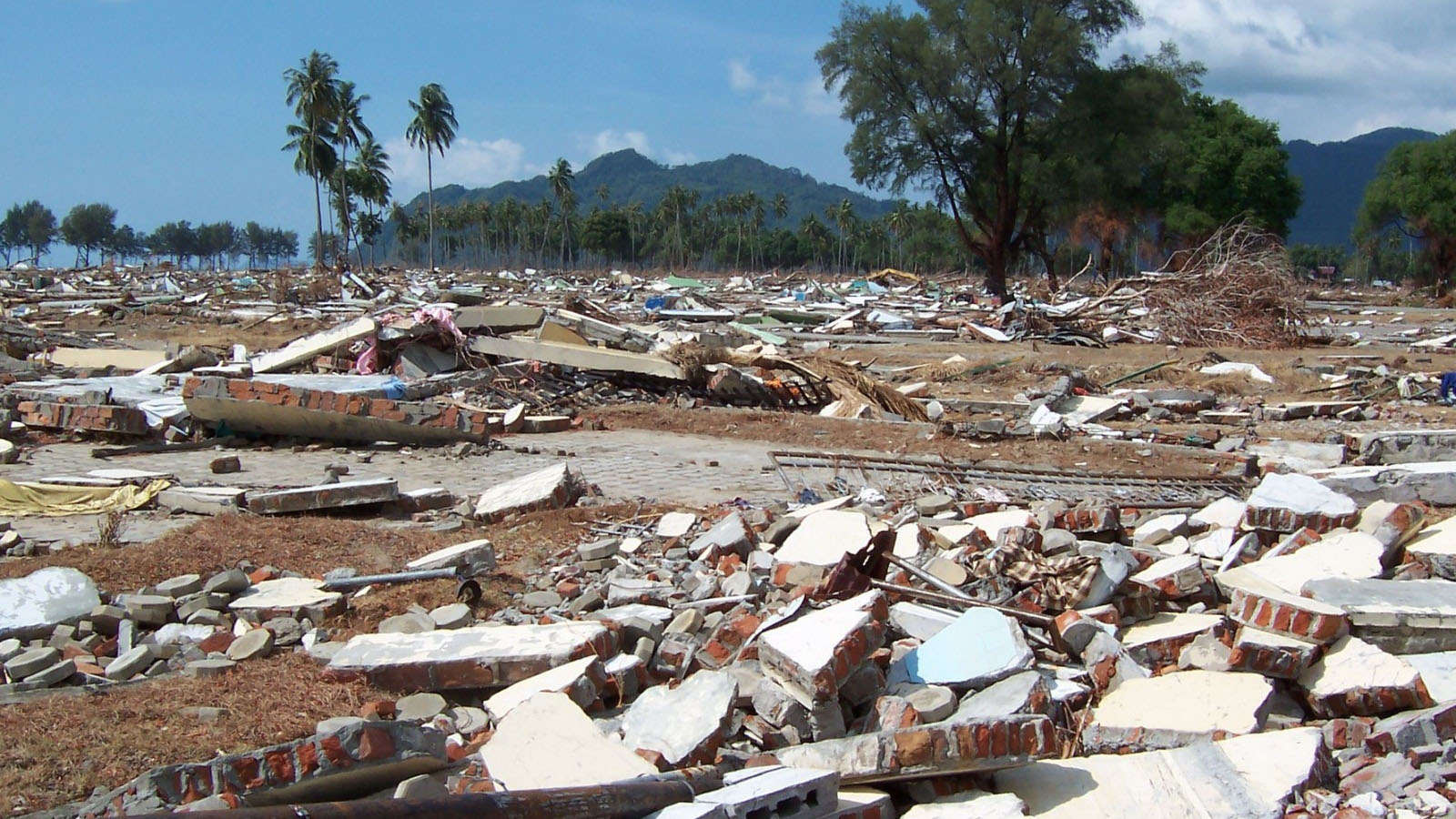 Des hommes recherchent toujours un membre de leur famille dans leur maison endommagée au village de Balaroa à Palu le 1er octobre 2018, suite au tremblement de terre et au tsunami qui ont frappé la région le 28 septembre.