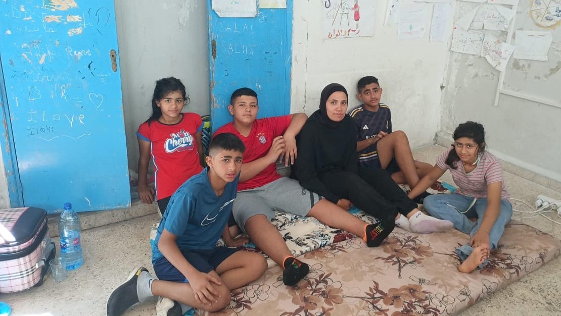 A mother and her 5 children are sitting in a refuge