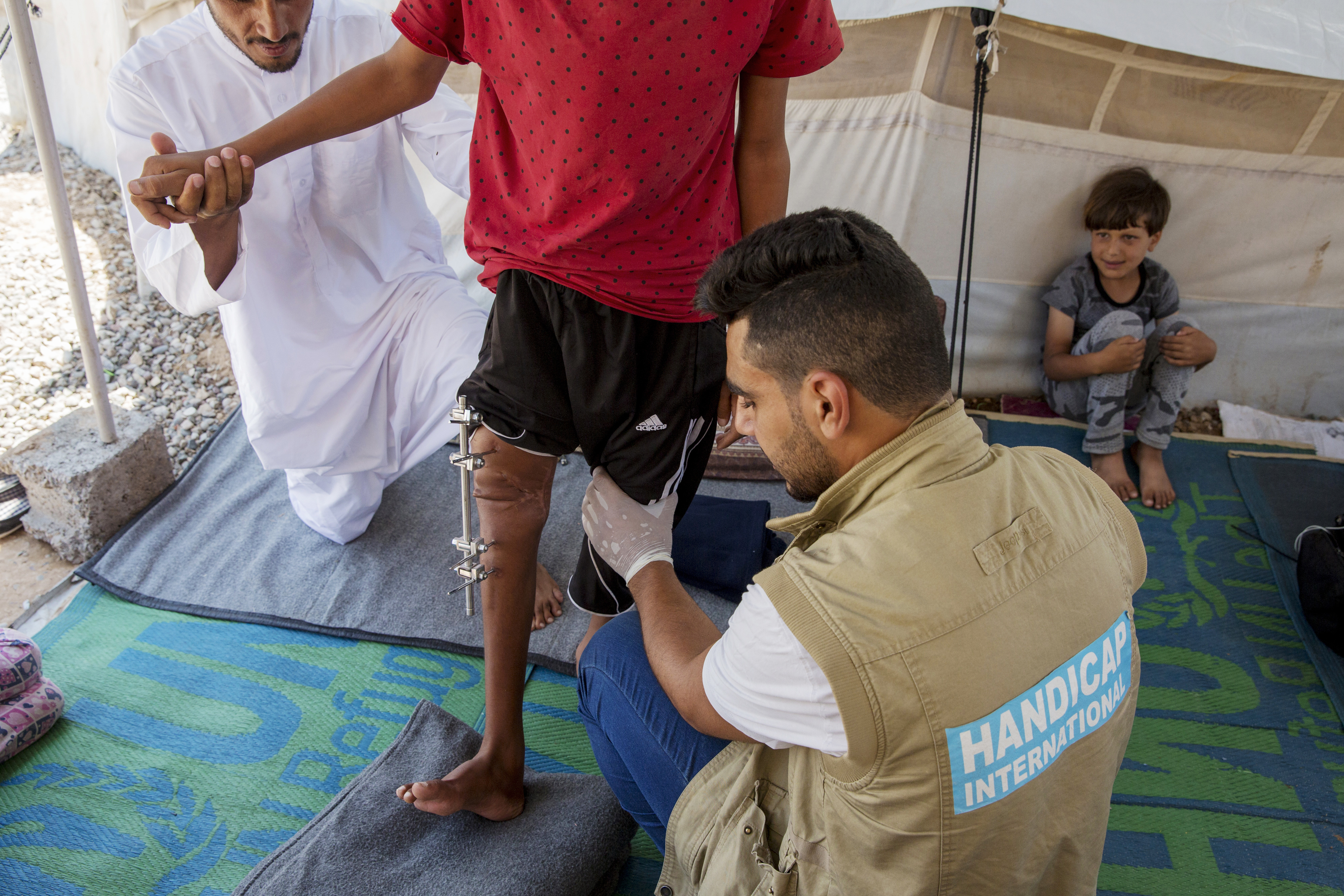 Mohammad, physiothérapeute de HI, en séance de rééducation avec Abdallah, 13 ans, originaire de Mossoul Ouest. Il souffre d’une fracture de la jambe suite à l'explosion d'un missile.