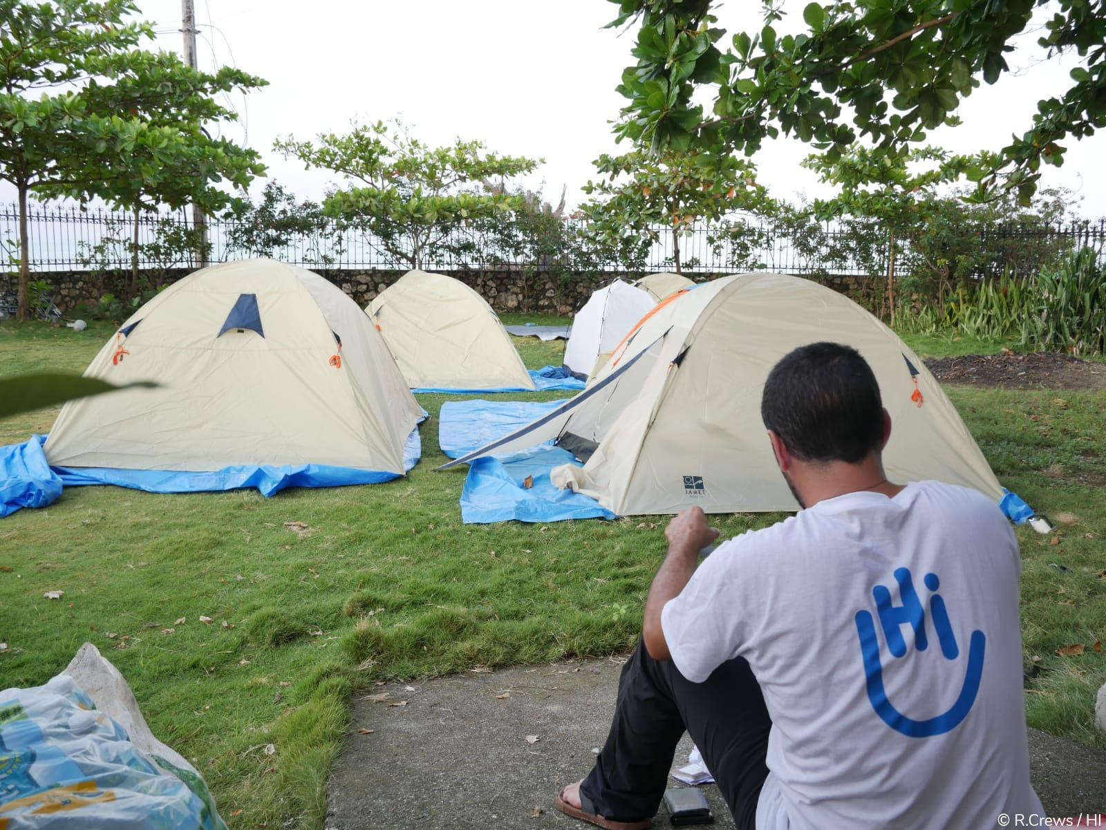 Membre de l'équipe d'urgence de HI, devant le camp de HI à l'extérieur des Cayes après le tremblement de terre en Haïti. Août 2021.