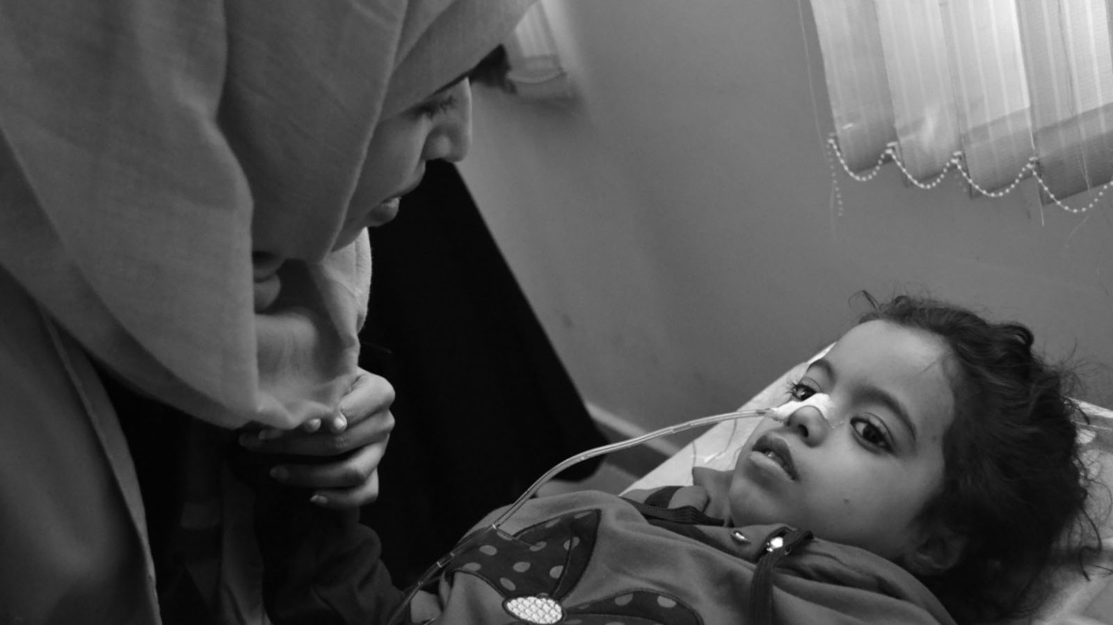 Rehabilitation session for a patient injured in an airstrike. After a tracheotomy and surgery on his leg, he can now walk with help. 