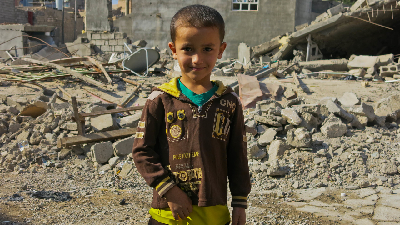 Le fils de Khaled, devant la maison de son oncle, dont il ne reste que des ruines.