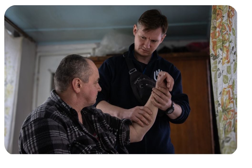 Un homme qui aide une personne en situation de handicap.