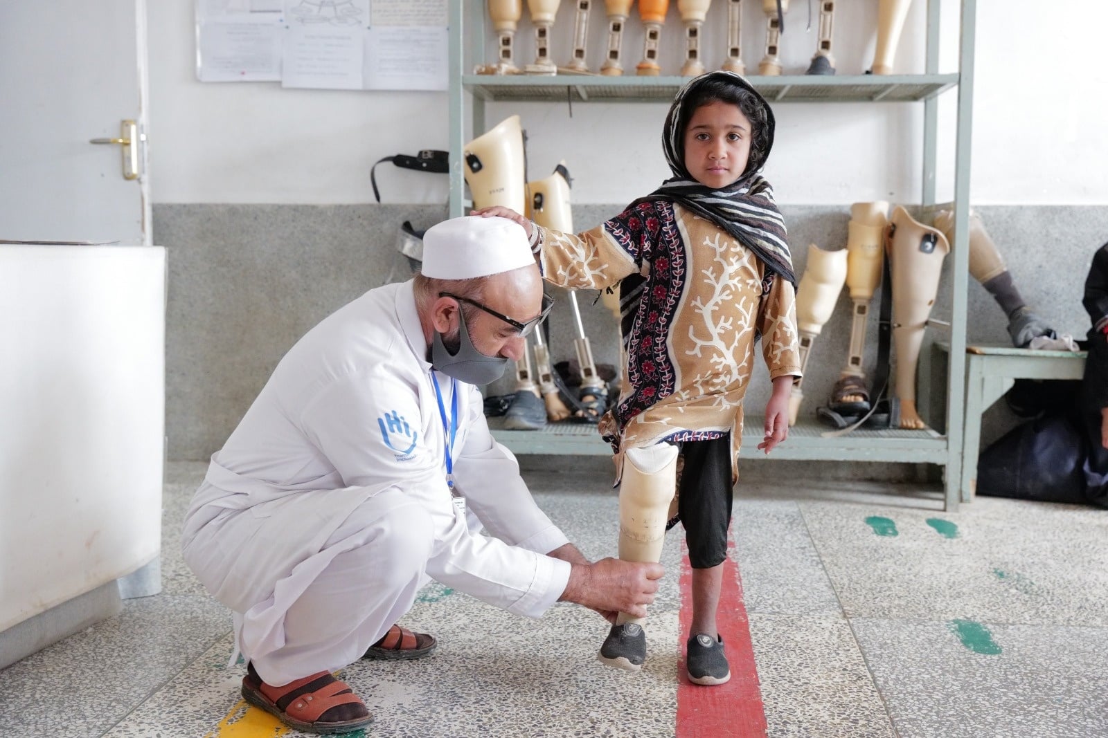 A doctor helping a little disabled girl inside 