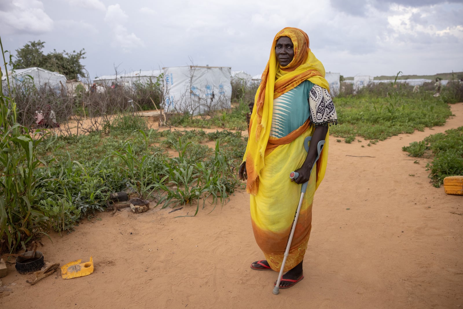 A woman with a disability outside holding crutches.