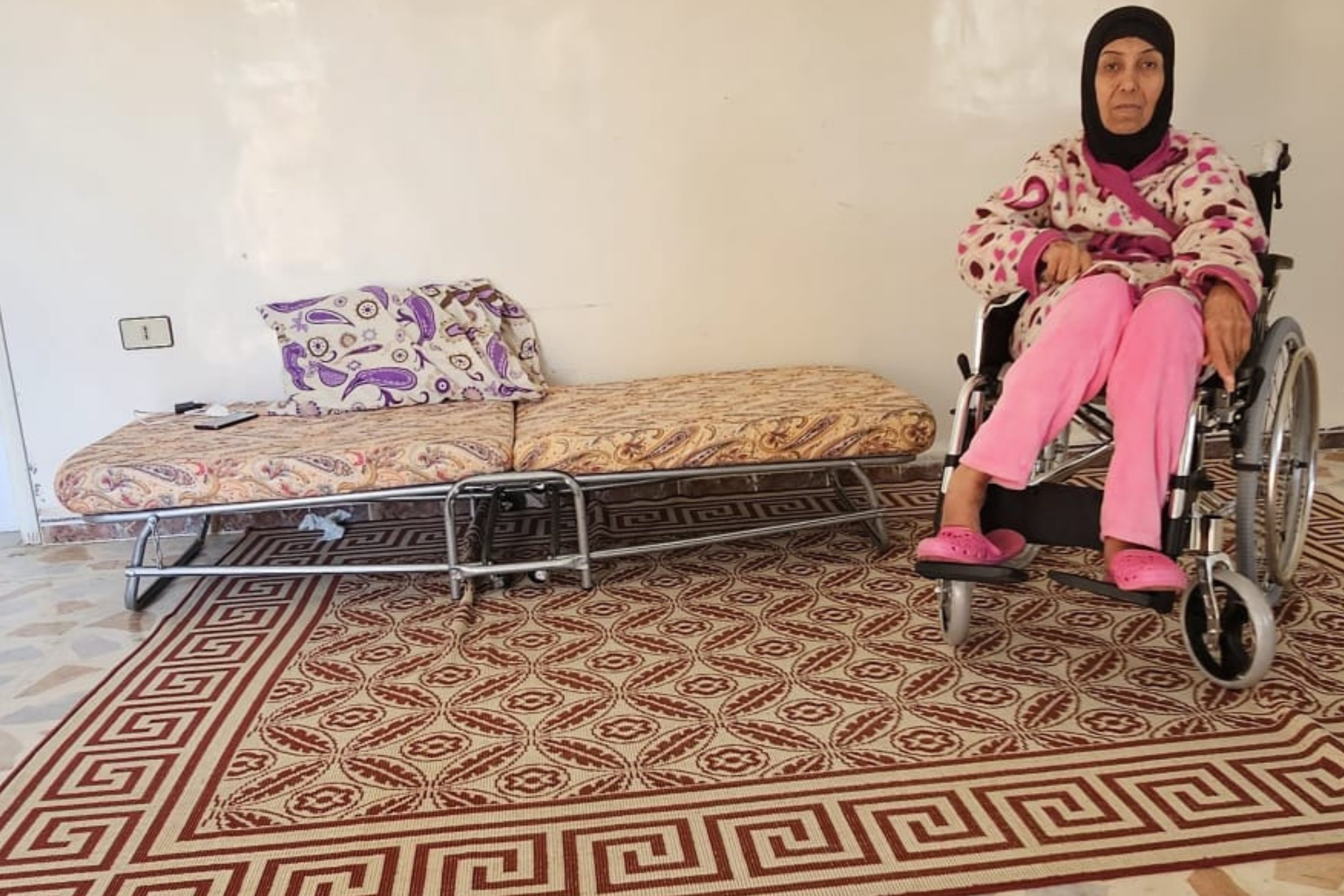 A young girl smiles as a doctor adjusts her prosthetic leg