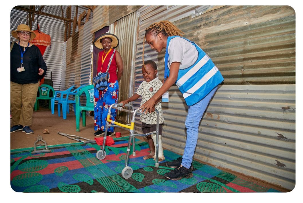 Woman helping a little child walk.