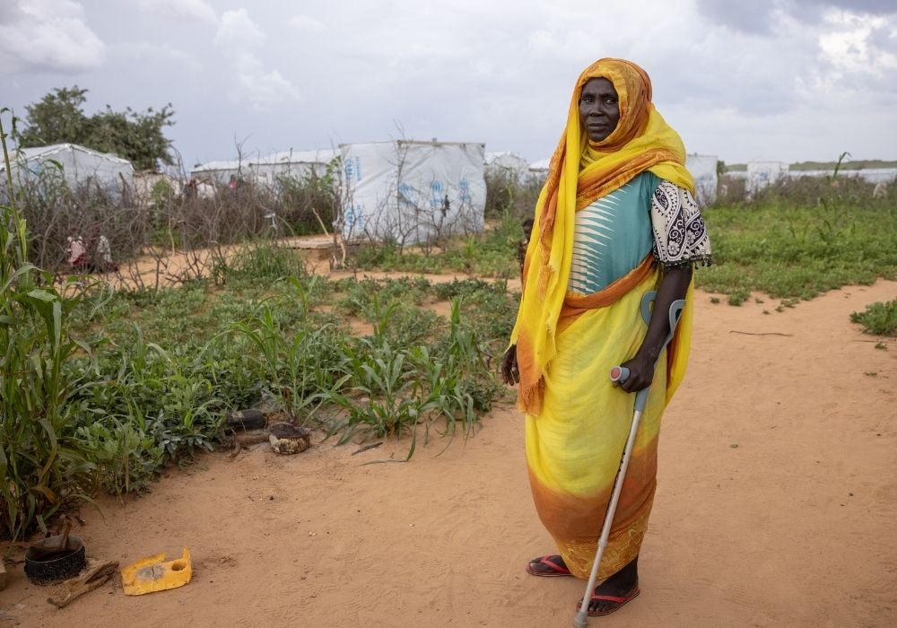 disabled woman standing outside with a stick
