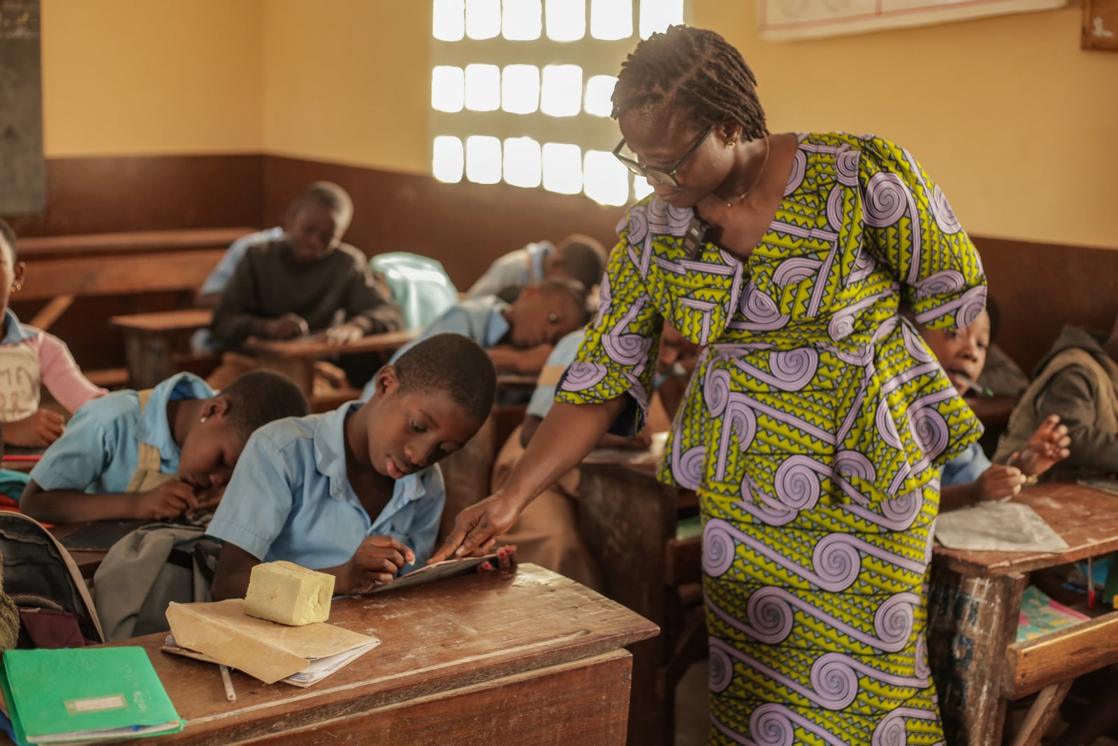 Students in a classroom being taught by a teacher.