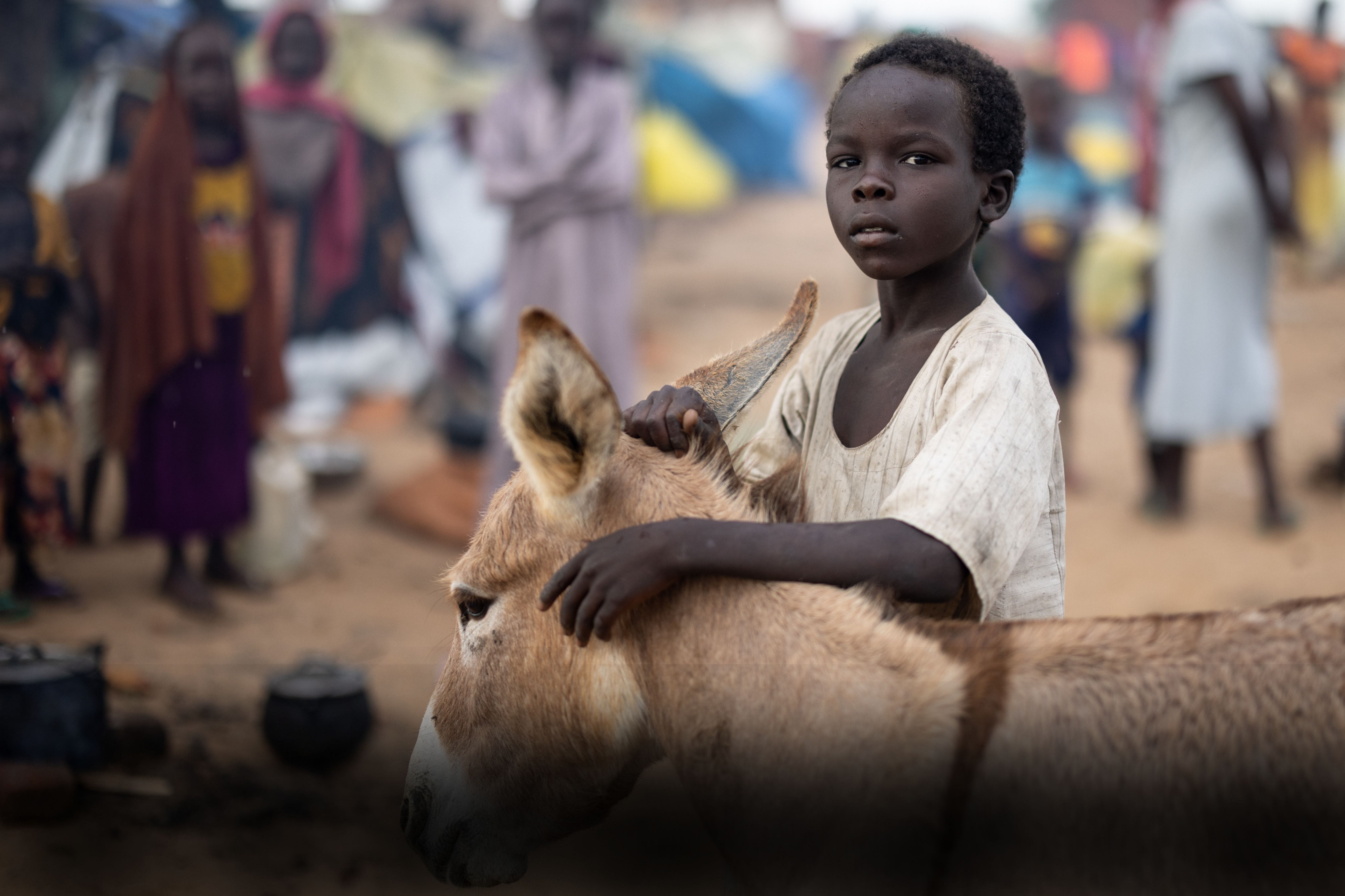 A young girl smiles as a doctor adjusts her prosthetic leg