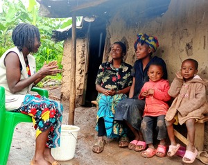 Béatrice, Rose et leur famille reçoivent la visite d'une agente de santé mentale et de soutien psychosocial de HI pour une séance de suivi. © HI