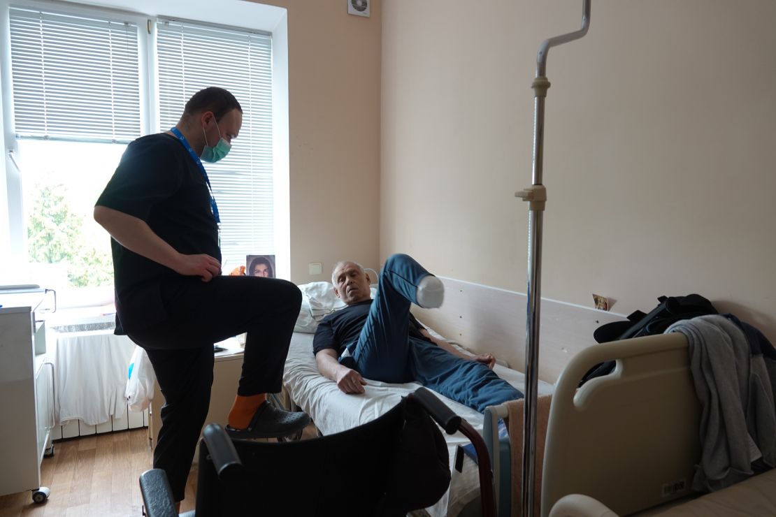 Ruslan, the physiotherapist who is treating him, shows him some exercises to do on his own once he is out of hospital. 