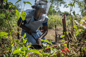 Fatou Diaw, one of Elisabeth’s colleagues, in the process of removing a mine. © M. Simoncelli / HI