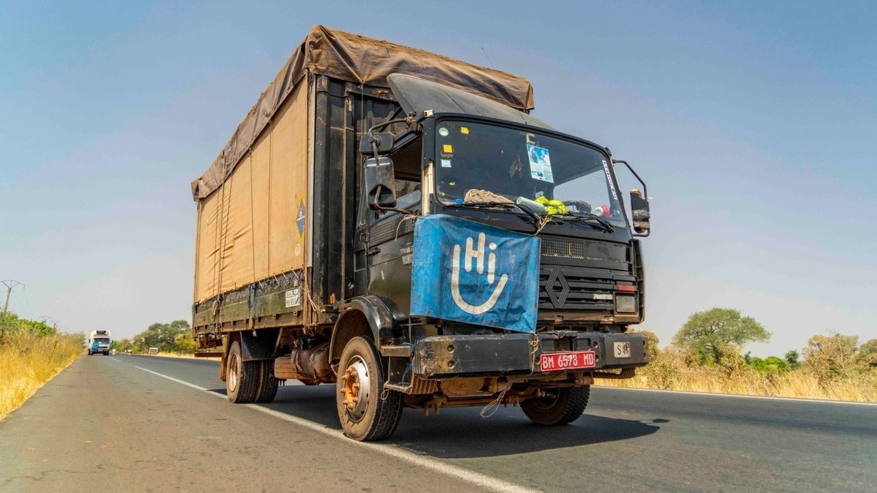 Un camion roule sur une route avec un drapeau HI sur le capot.