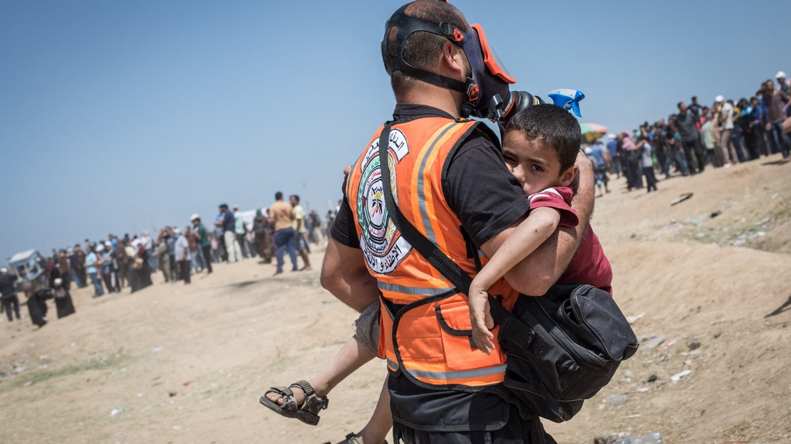 Un médecin porte un enfant dans une ambulance après qu'il a respiré du gaz lacrymogène le 14 mai 2018 à Gaza