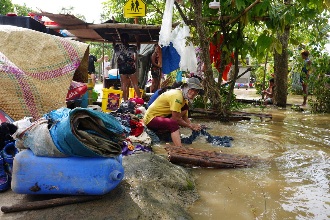 Une femme lave des habits dans le fleuve à coté d'un abris de fortune Amalia, 54 ans, habitante de la ville de Libon dans la province d’Albay et mère de 13 enfants a perdu tous ses biens lors du passage de la tempête. 
