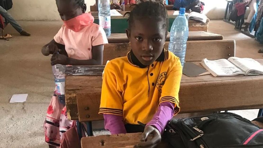 Aminata est retournée à l’école et étudie avec application en classe.