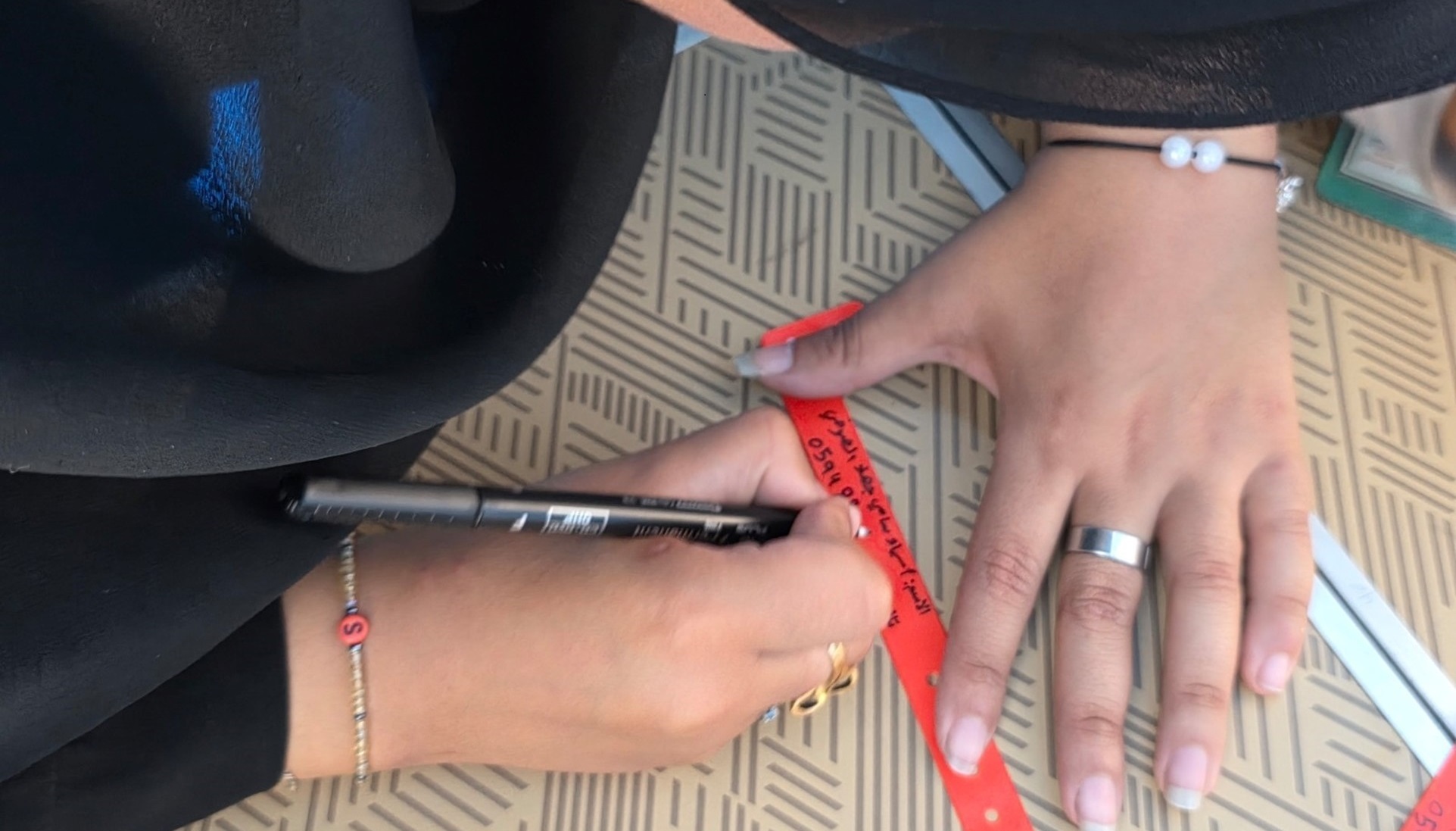 Une mère de famille inscrit ses coordonnées sur un bracelet 