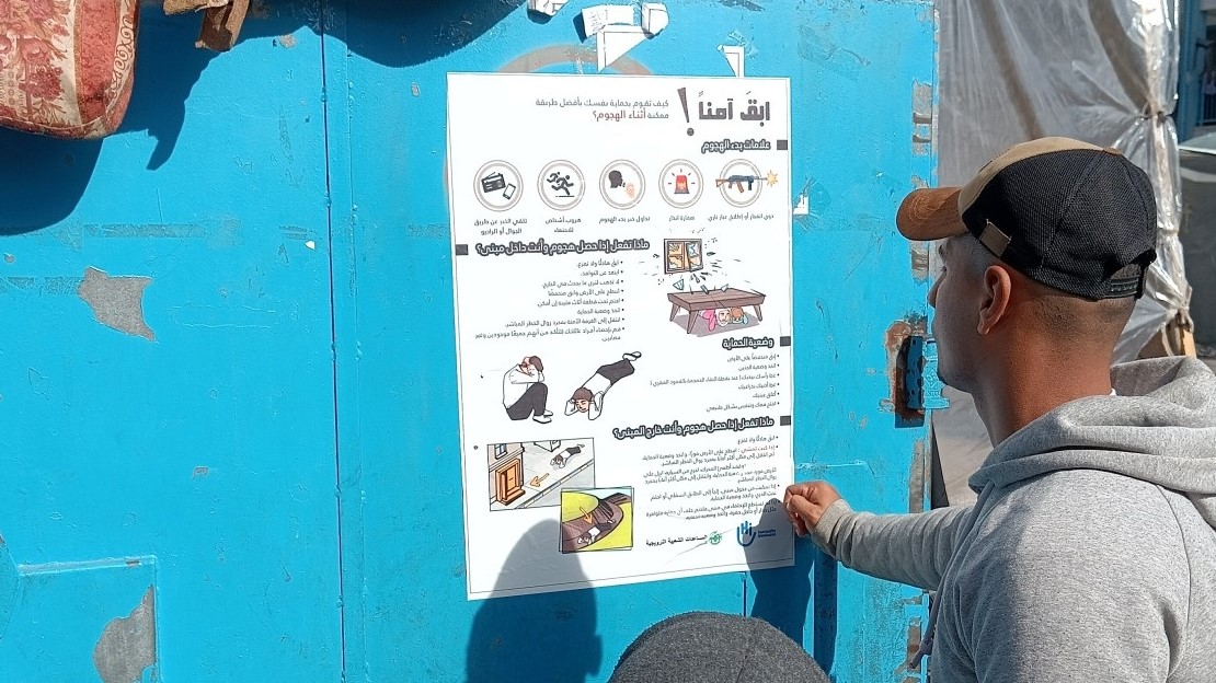 HI installe des affiches dans les camps de déplacés expliquant comment se protéger au mieux en cas de bombardements et de pilonnages - Khan Younis, dans la bande de Gaza.