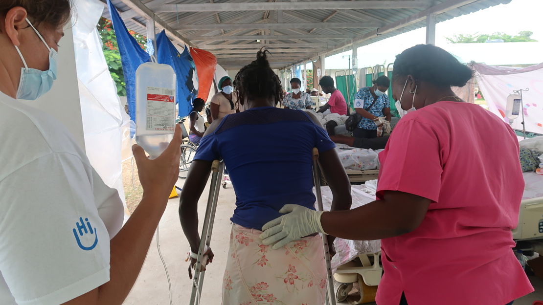 An HI rehabilitation specialist and partner physical therapist teach a woman to walk on her new crutches after breaking her tibia in the earthquake. Cayes, 2021