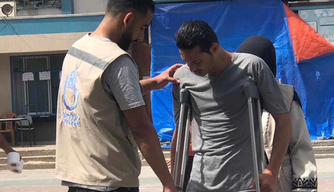 Haitham dans un camp de déplacés, aidant un bénéficiaire