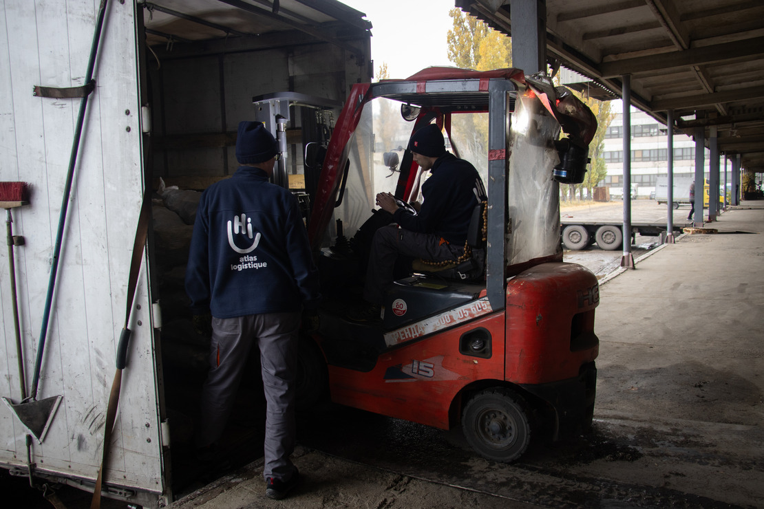 Des agents d’Atlas Logistique charge des briquettes de combustible solide dans un camion en novembre 2024 à Dnipro, dans l’Est de Ukraine. 