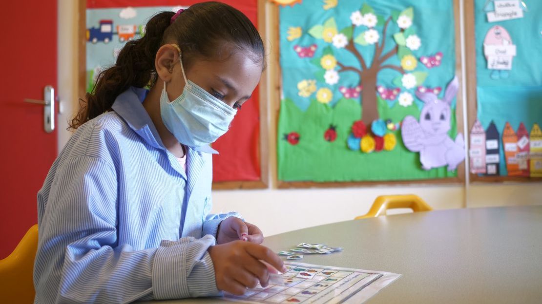 Imane, dans sa classe, utilisant un support visuel pour réaliser une activité proposée. 