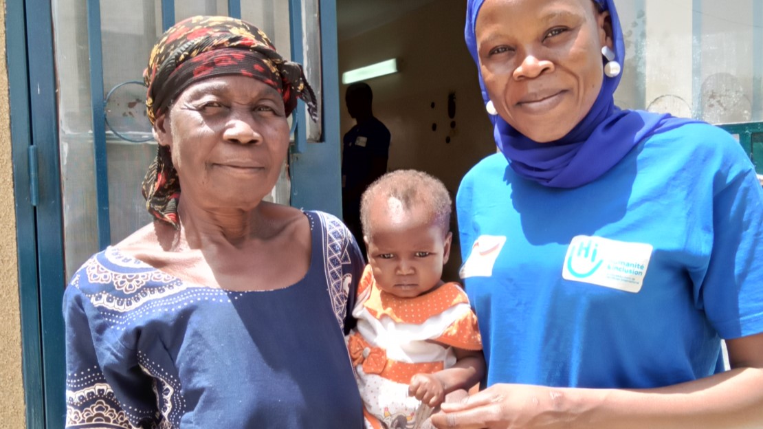 Damaris et sa petite fille, Ruth, en compagnie de la kinésithérapeute de HI, Angeline.