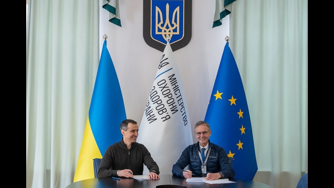 Le ministre de la Santé en Ukraine, Viktor Liashko (à gauche) et le directeur du programme Ukraine chez HI, Christian Fuchs (à droite) sont assis l'un à côté de l'autre et signe un protocole d'accord.