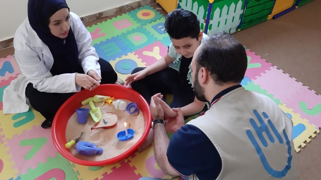 Abd Alnor au centre avec sa mère et son physiothérapeute