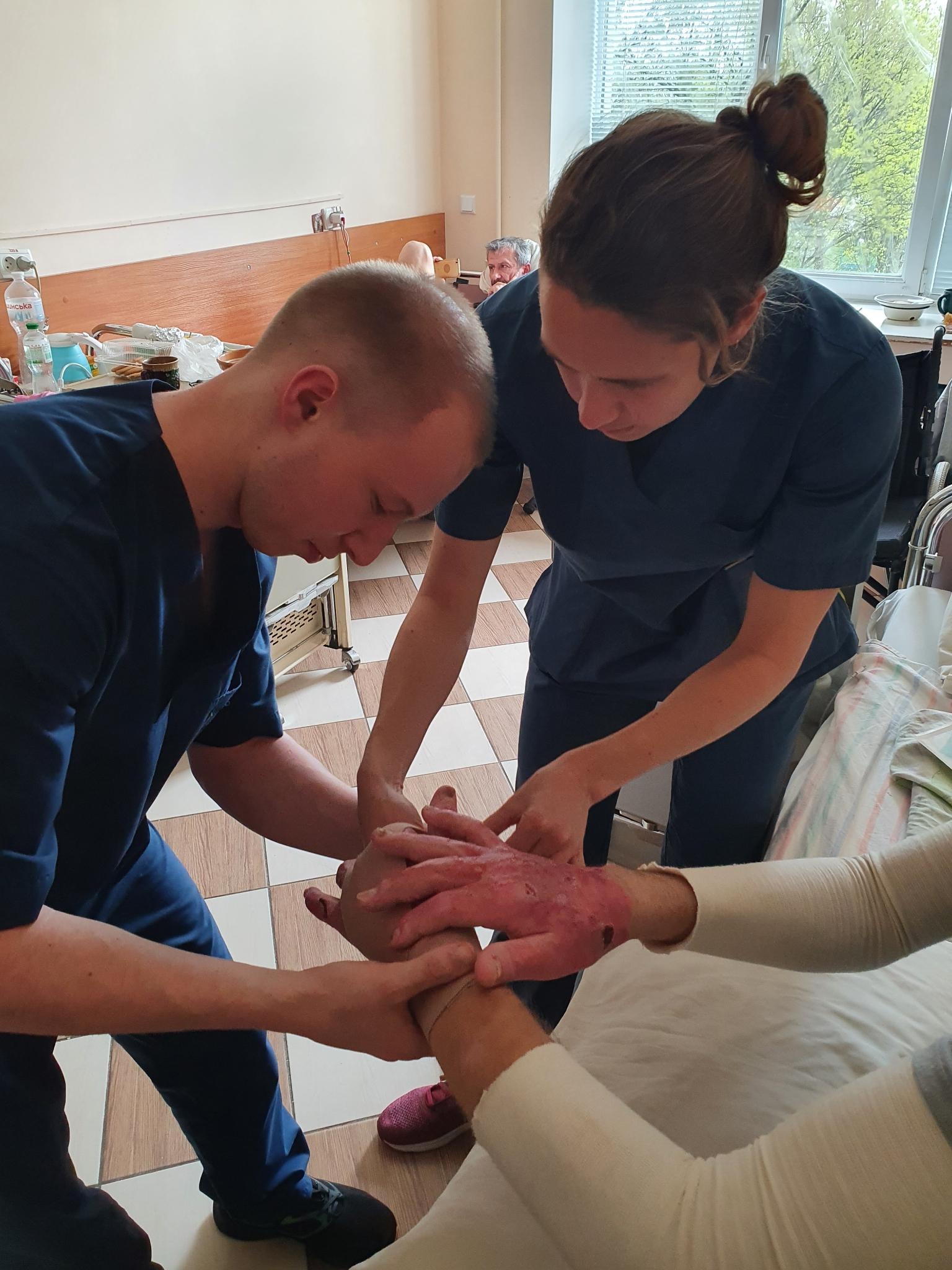 Violette donne une formation pratique à Ivan, un étudiant en kinésithérapie en Ukraine